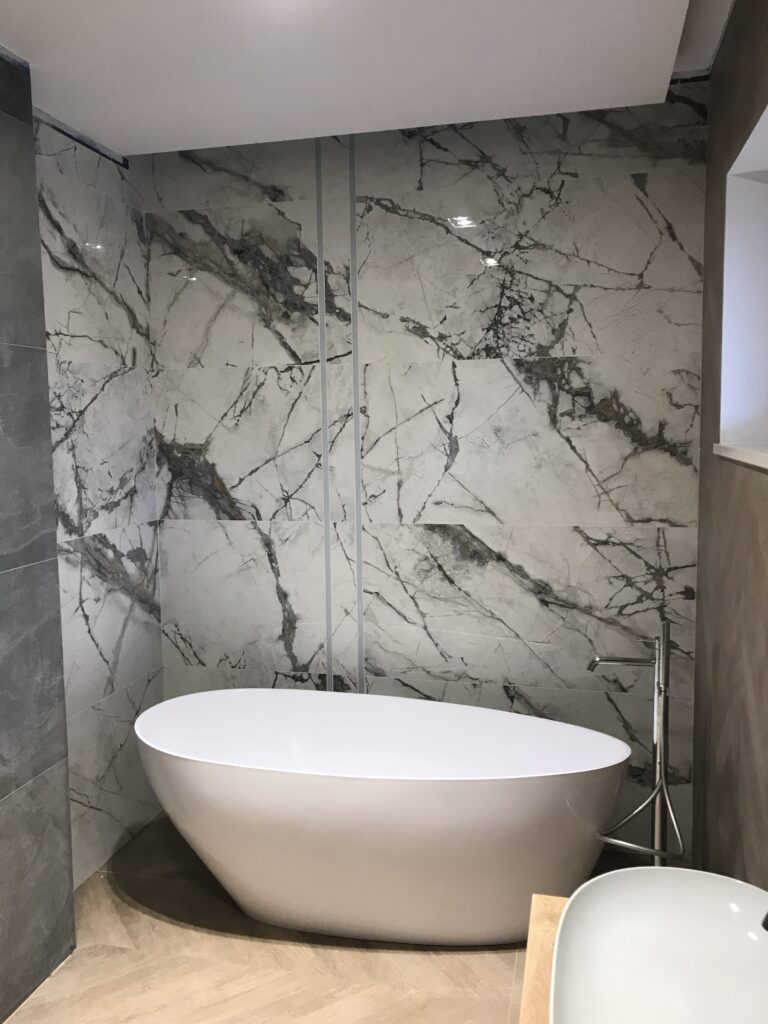Wolnostojąca wanna w łazience z płytkami wielkoformatowymi